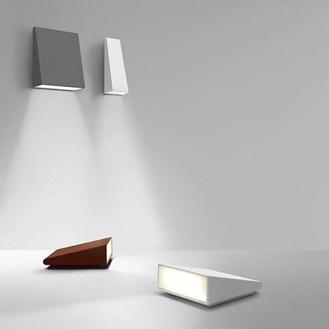 Artemide Cuneo: due applique da parete grigia e bianca con fasci di luce verso il basso, più due versioni da tavolo a cuneo in terracotta e bianco.