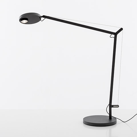 Artemide Demetra Professional desk lamp in black, featuring adjustable articulated arm, circular LED head, and round weighted base