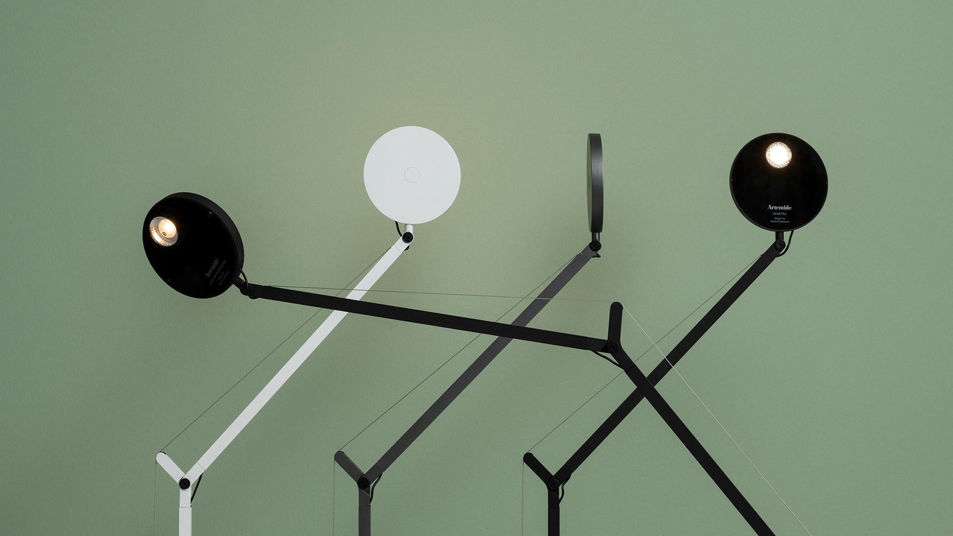 Tre lampade da tavolo Artemide Demetra Tavolo in grigio scuro, nero e bianco, con teste sferiche su bracci articolati e basi circolari