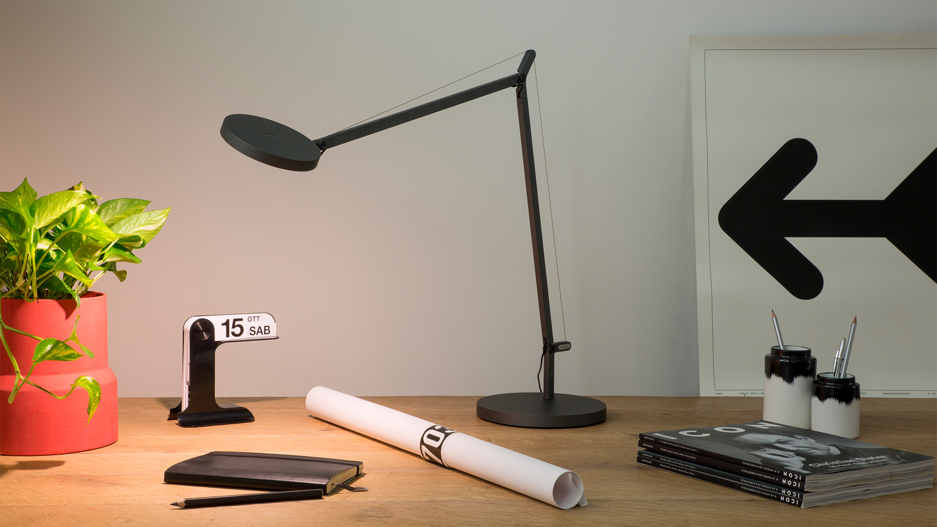 Testa della lampada da tavolo Artemide Demetra: diffusore ovale scuro con striscia LED centrale, montata su braccio regolabile con anello passacavo