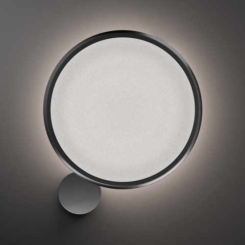 Lampada da parete Artemide Discovery Parete: grande diffusore circolare con anello in metallo scuro che emette un alone di luce soffusa, piccolo supporto rotondo in basso