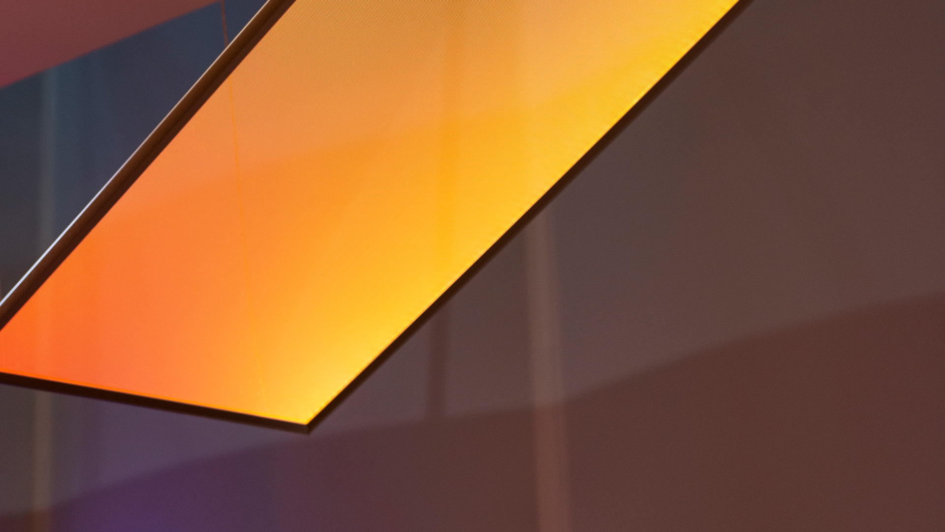 Lampada a sospensione rettangolare Artemide Discovery Space con luce viola su scrivania bianca in ufficio con pareti color ottanio