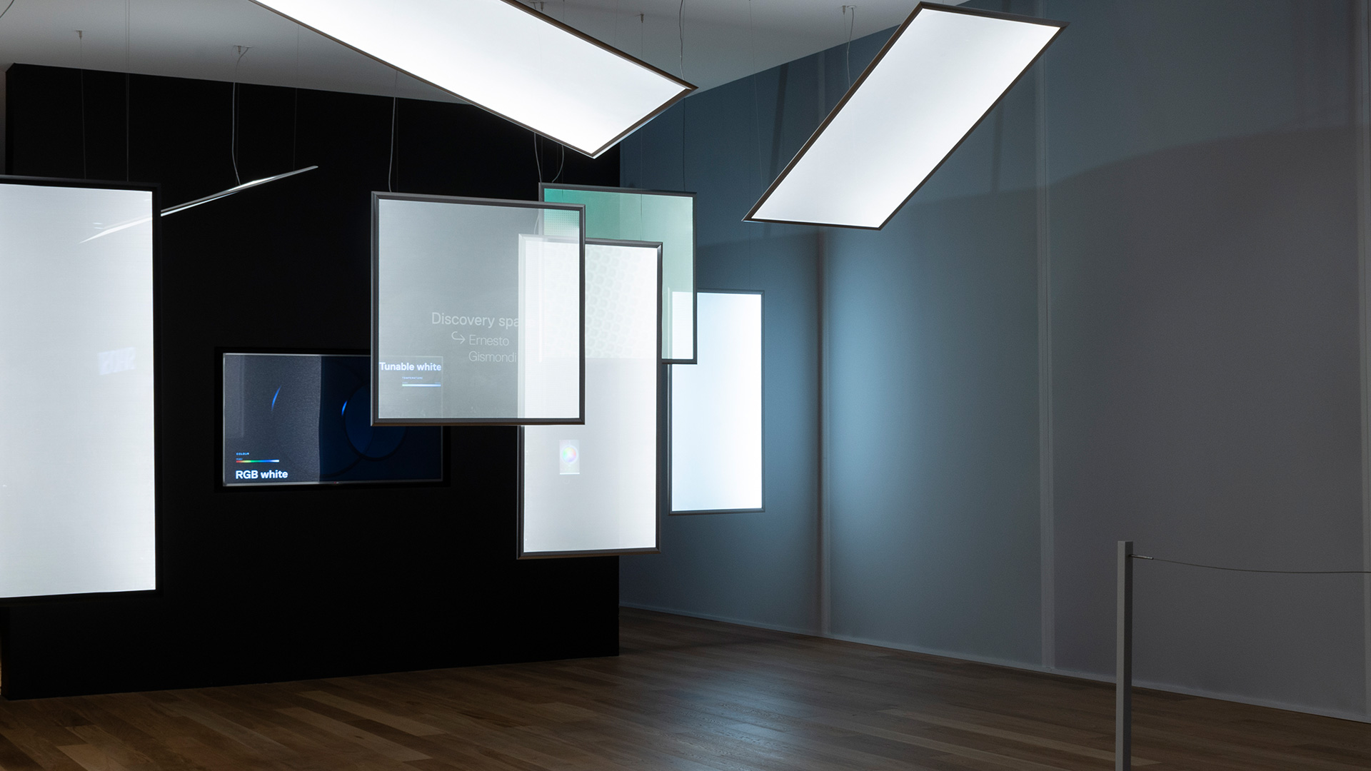 Lampada a sospensione rettangolare Artemide Discovery Space in un luminoso caffè con pareti gialle, mobili bianchi e tavolini.