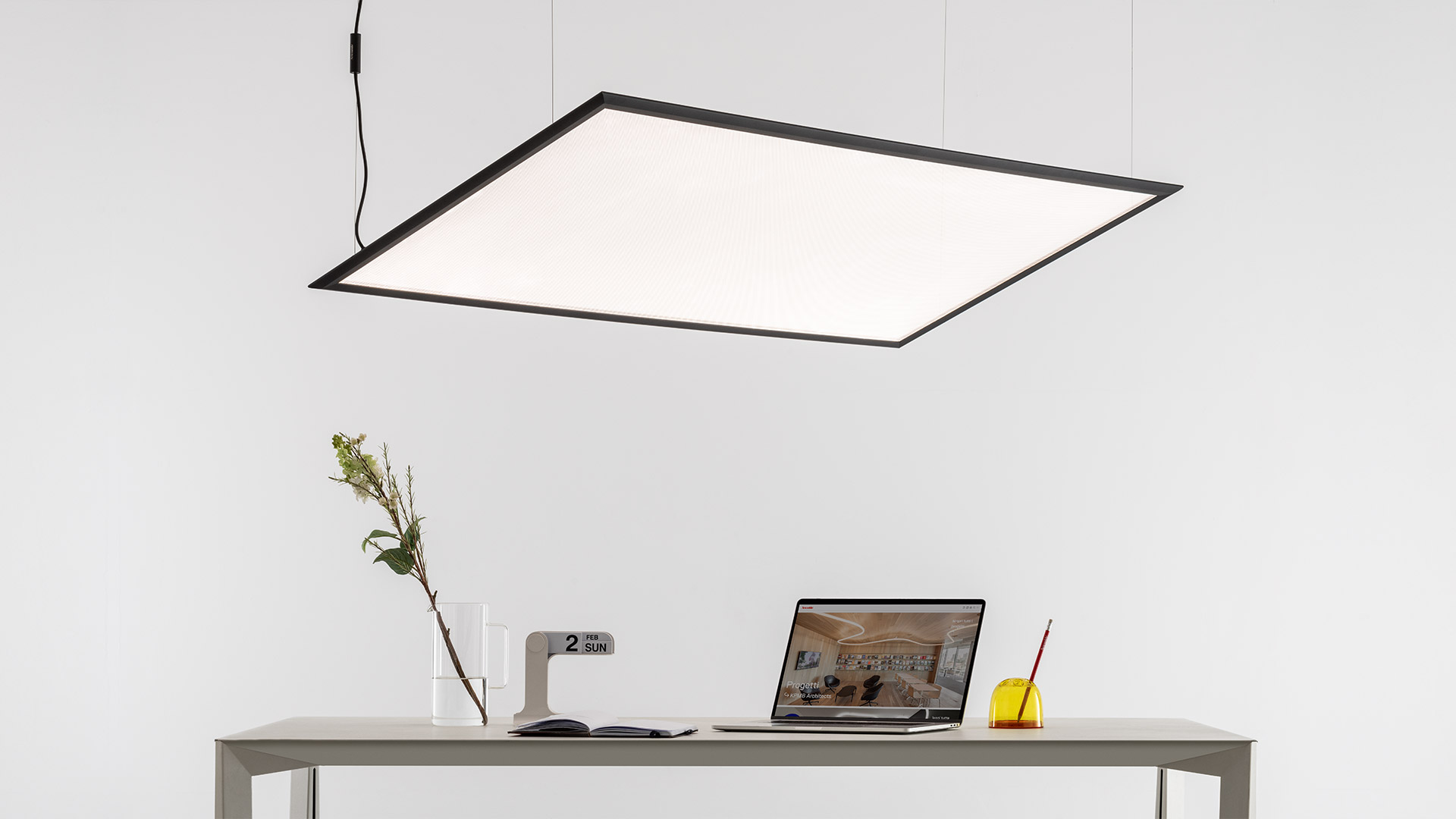 Lampada da soffitto Artemide Discovery Space che emette luce calda con gradiente arancio-giallo attraverso un pannello rettangolare su superficie scura