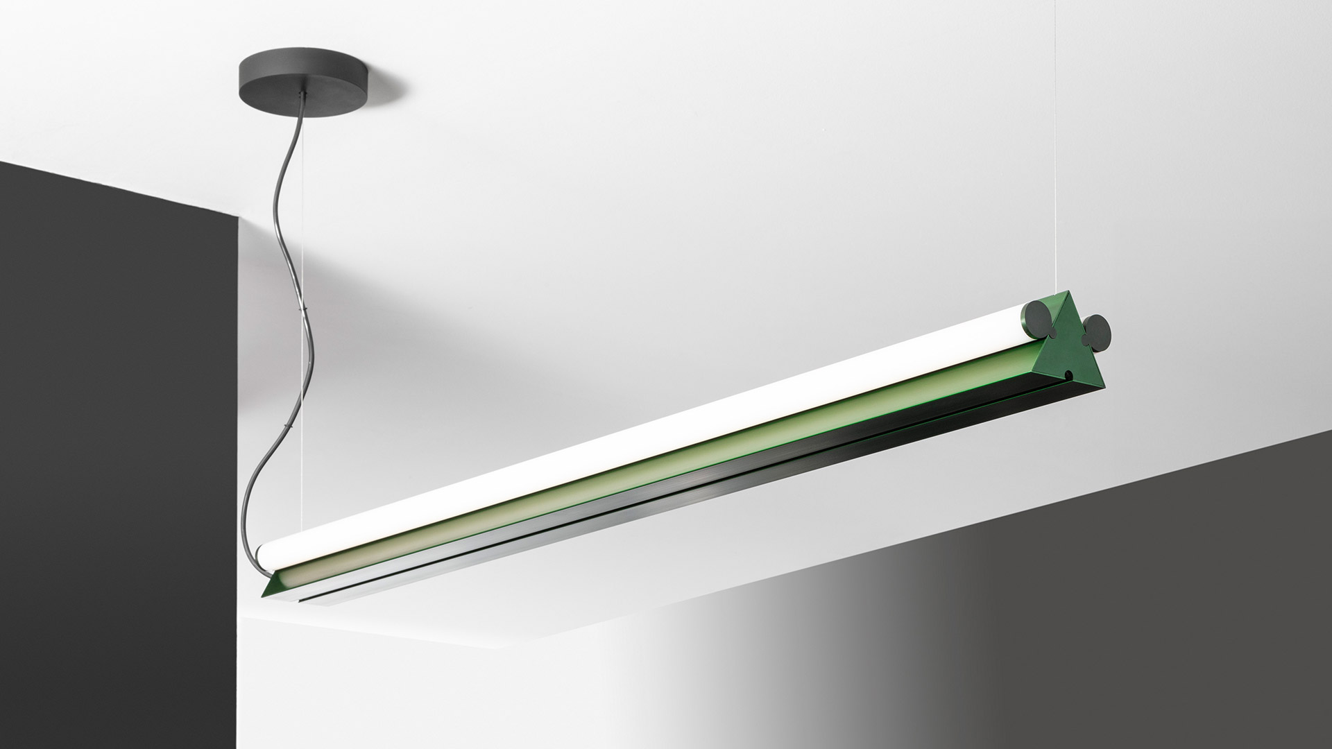 Artemide Dreispitz: slim cylindrical LED lamps in horizontal ceiling and vertical pendant configurations, metallic finish on dark background