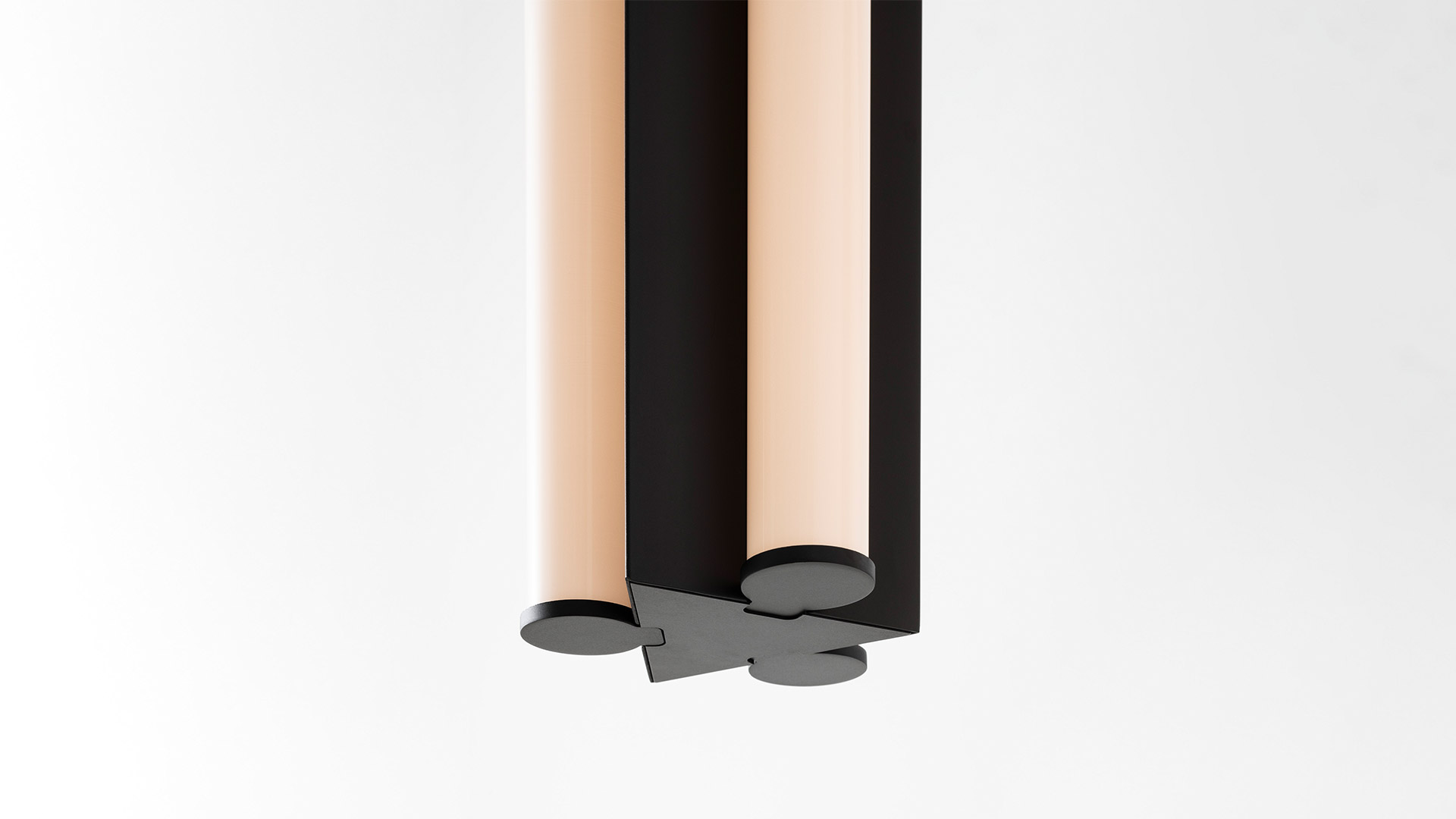 Three Artemide Dreispitz pendant lamps hanging on thin cords: two in green glass and one in chrome, cylindrical tubular design