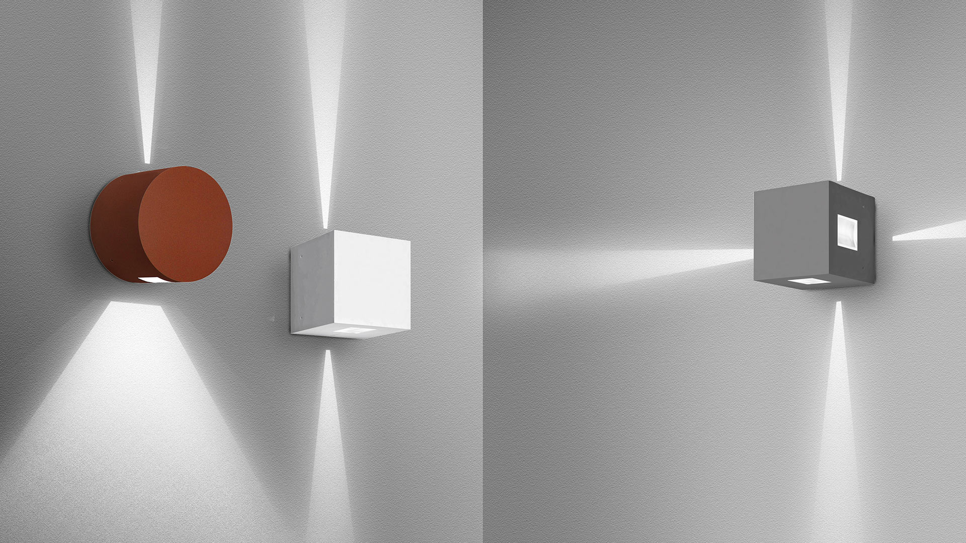 Tre applique Artemide Effetto con fasci di luce verso l'alto e il basso: versioni cilindriche terracotta, cubo bianco e cubo grigio