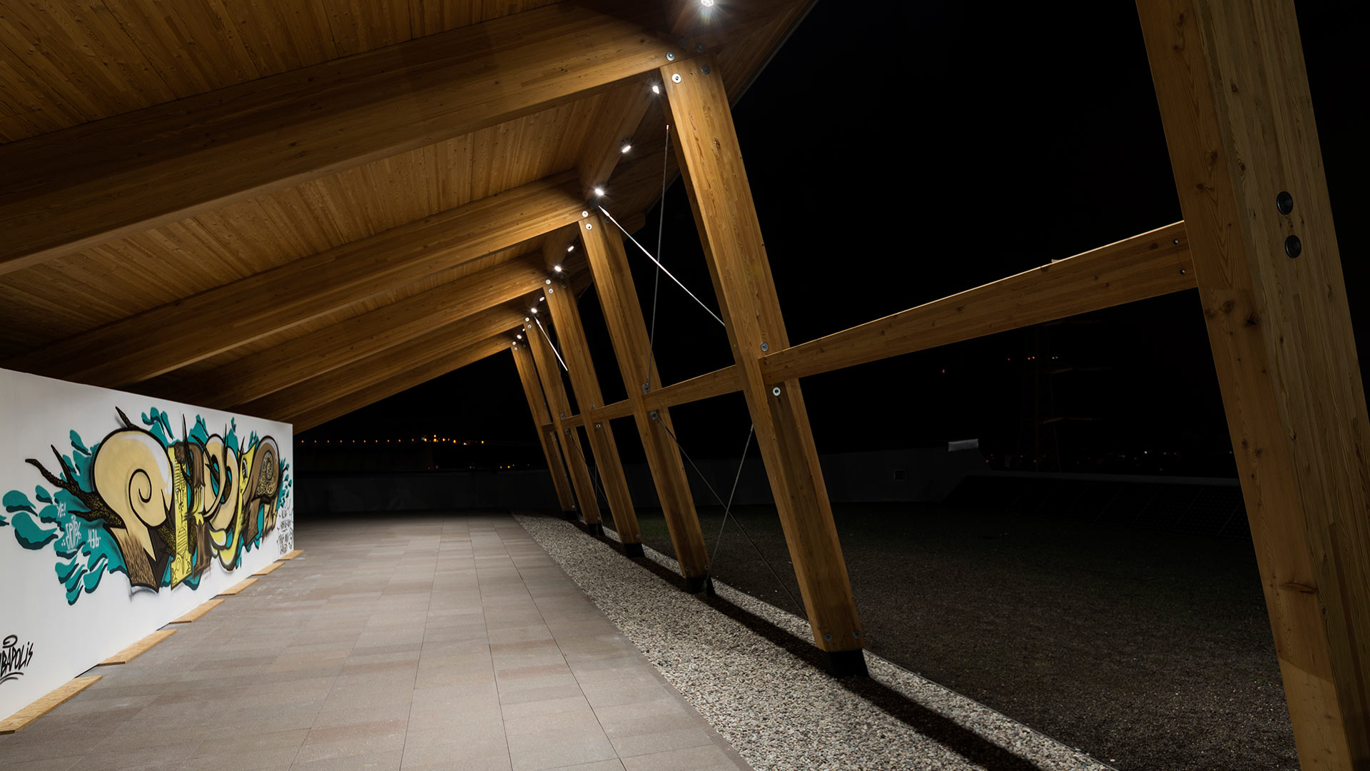 Faretto da incasso a terra Ego Spot LED per esterni con anello in acciaio spazzolato, proietta luce calda sull'erba verde di notte