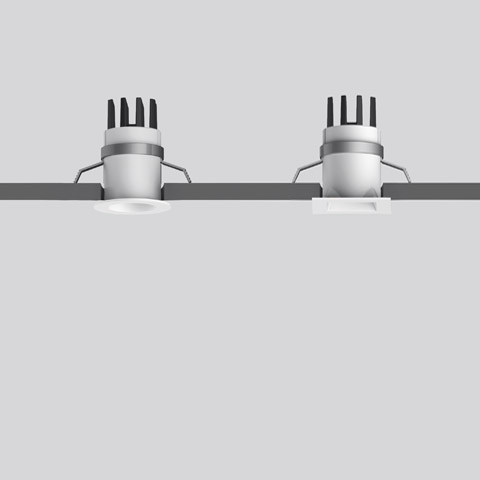 Due faretti da incasso a soffitto Artemide Everything 35 con cornice quadrata bianca e alette di dissipazione, montati a filo nel soffitto
