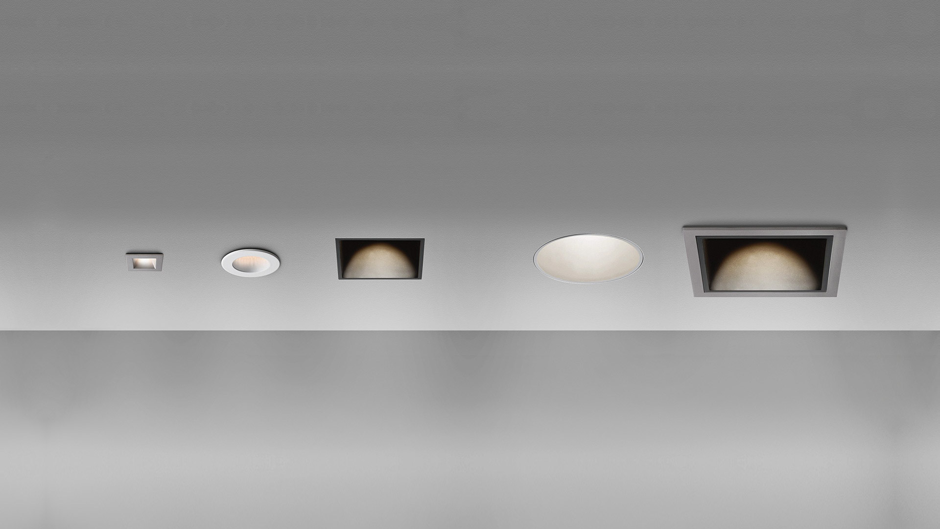 Cinque faretti da incasso a soffitto Artemide Everything in fila: dimensioni variabili, forme rotonde e quadrate, finiture bianche e scure