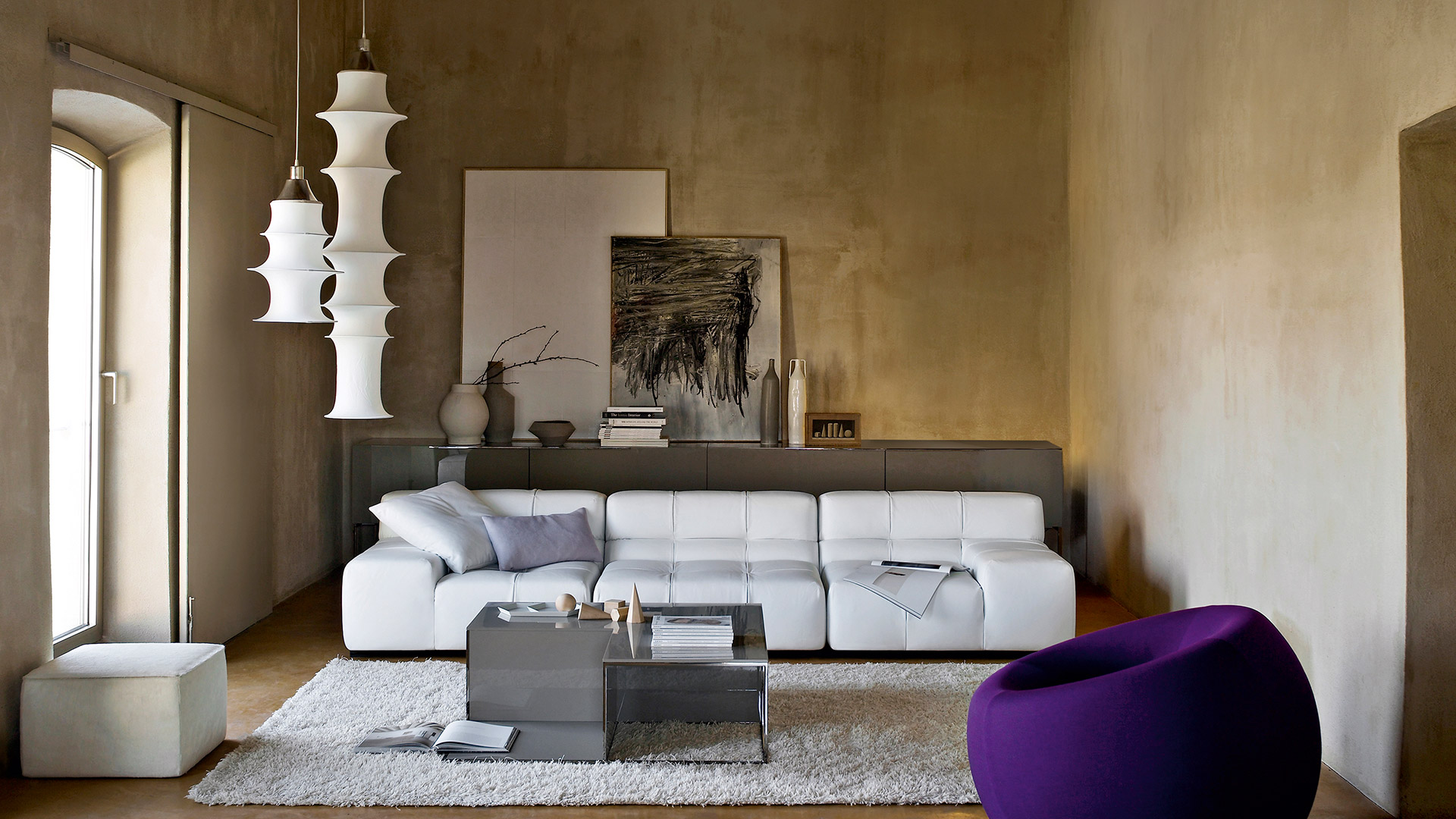Più lampade a sospensione Artemide Falkland con diffusori in tessuto bianco stratificati che creano forme organiche sovrapposte, sospese da cavi neri