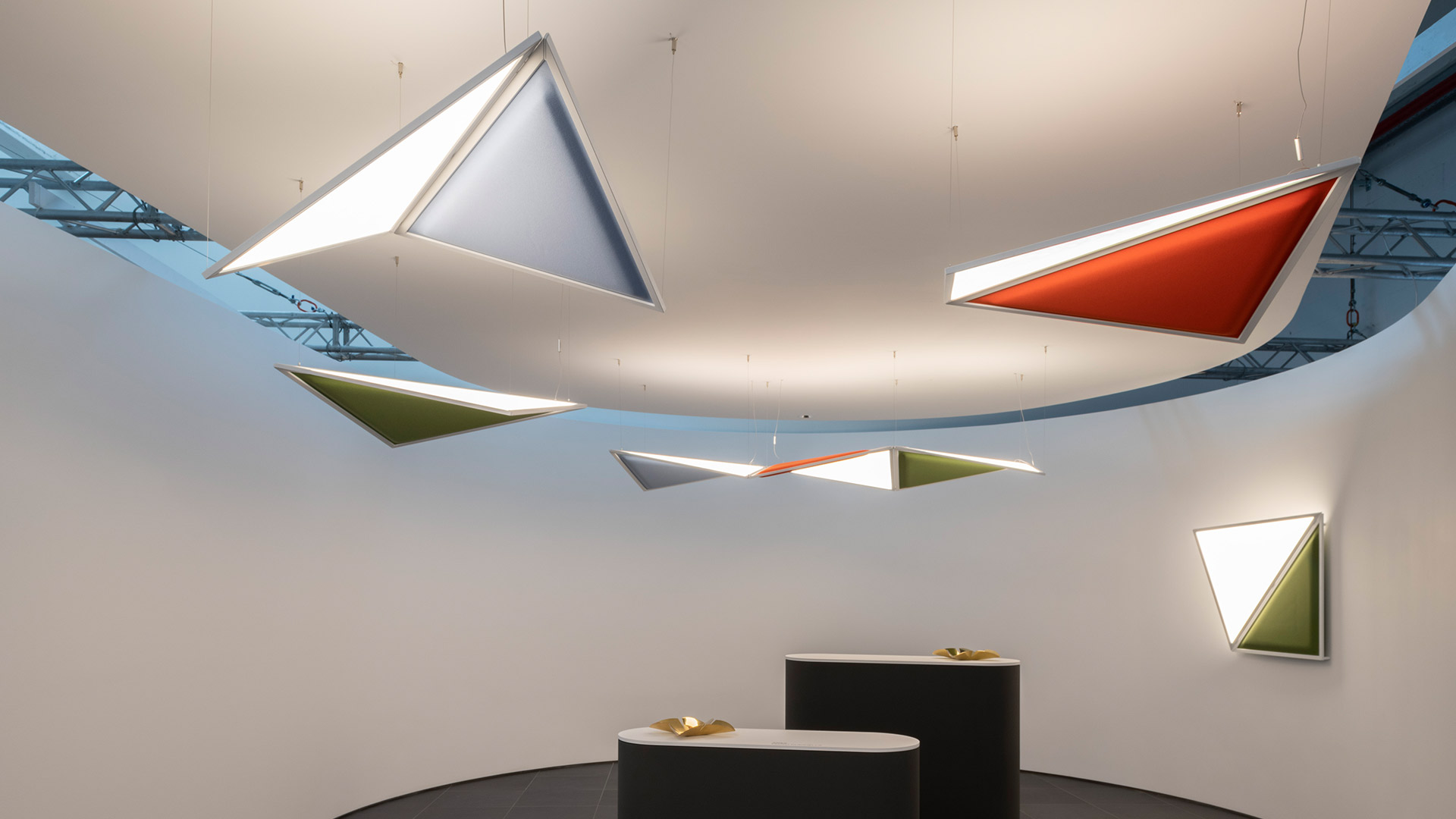 Lampada da parete Artemide Flexia: pannello luminoso triangolare bianco con sezione inferiore verde oliva in cornice argento