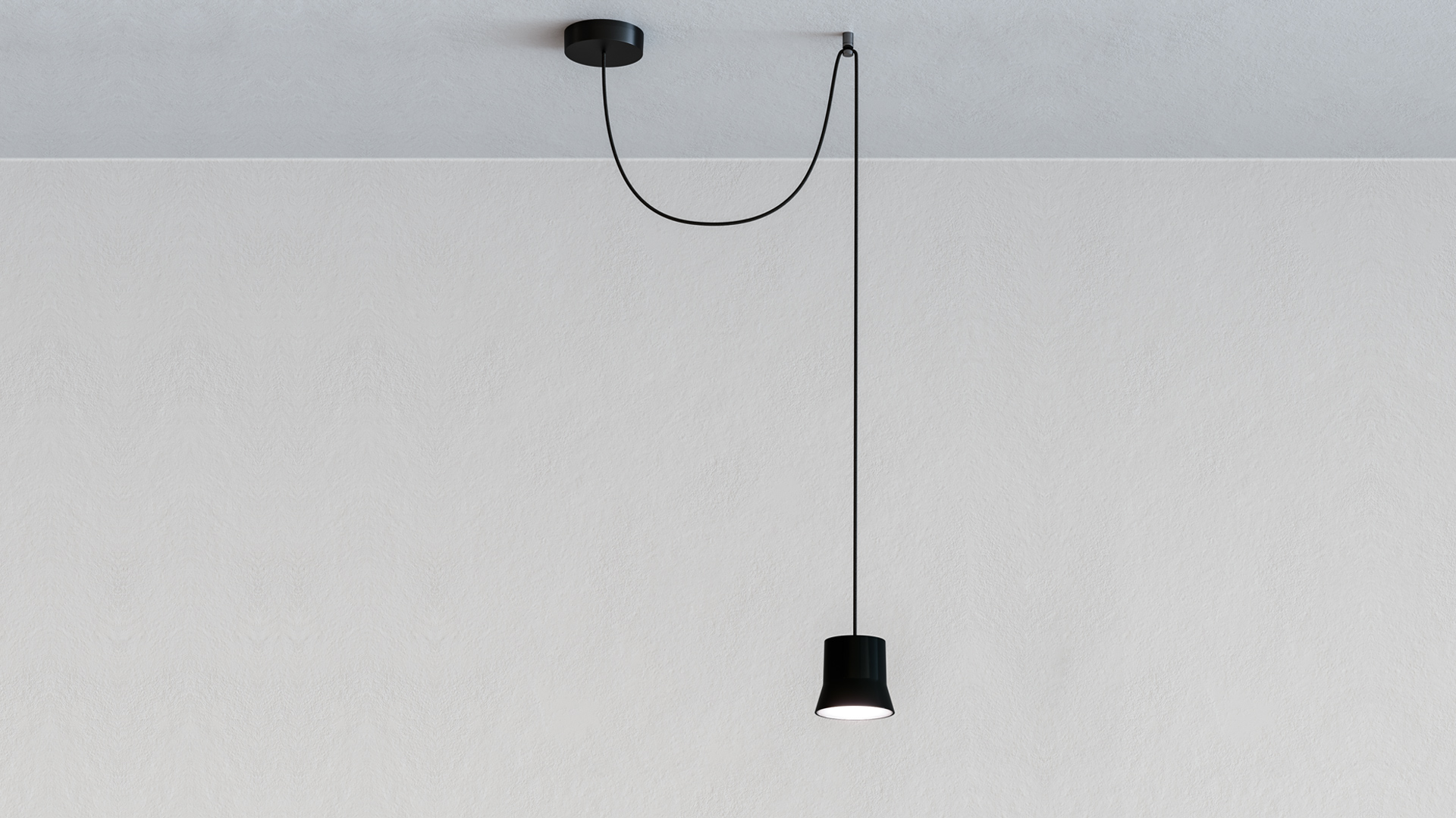 Artemide Giò Light Decentrata: lampada a sospensione nera con paralume cilindrico su cavo nero asimmetrico da rosone a soffitto decentrato