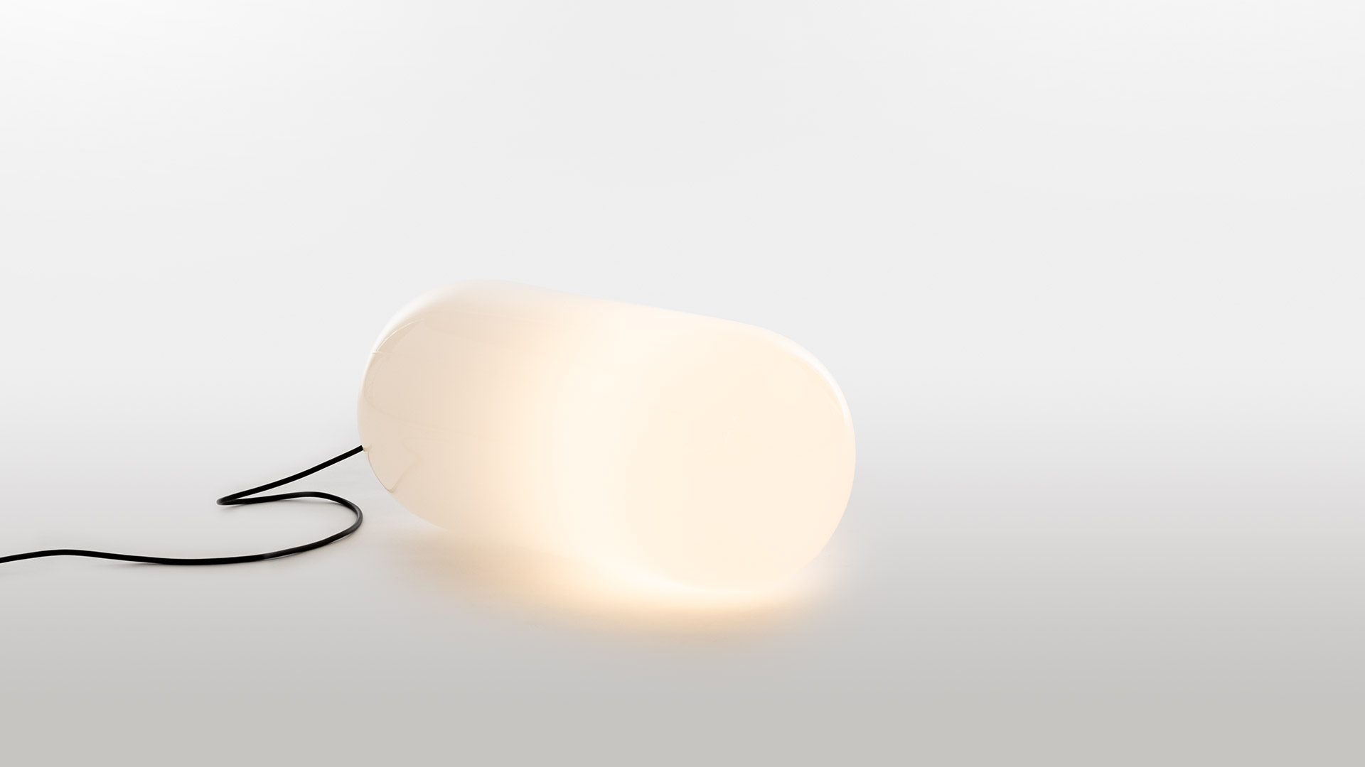 Artemide Gople Outdoor: lampada da tavolo bianca con diffusore in vetro organico su base a piedistallo e alta lampada da terra sottile, entrambe in bianco