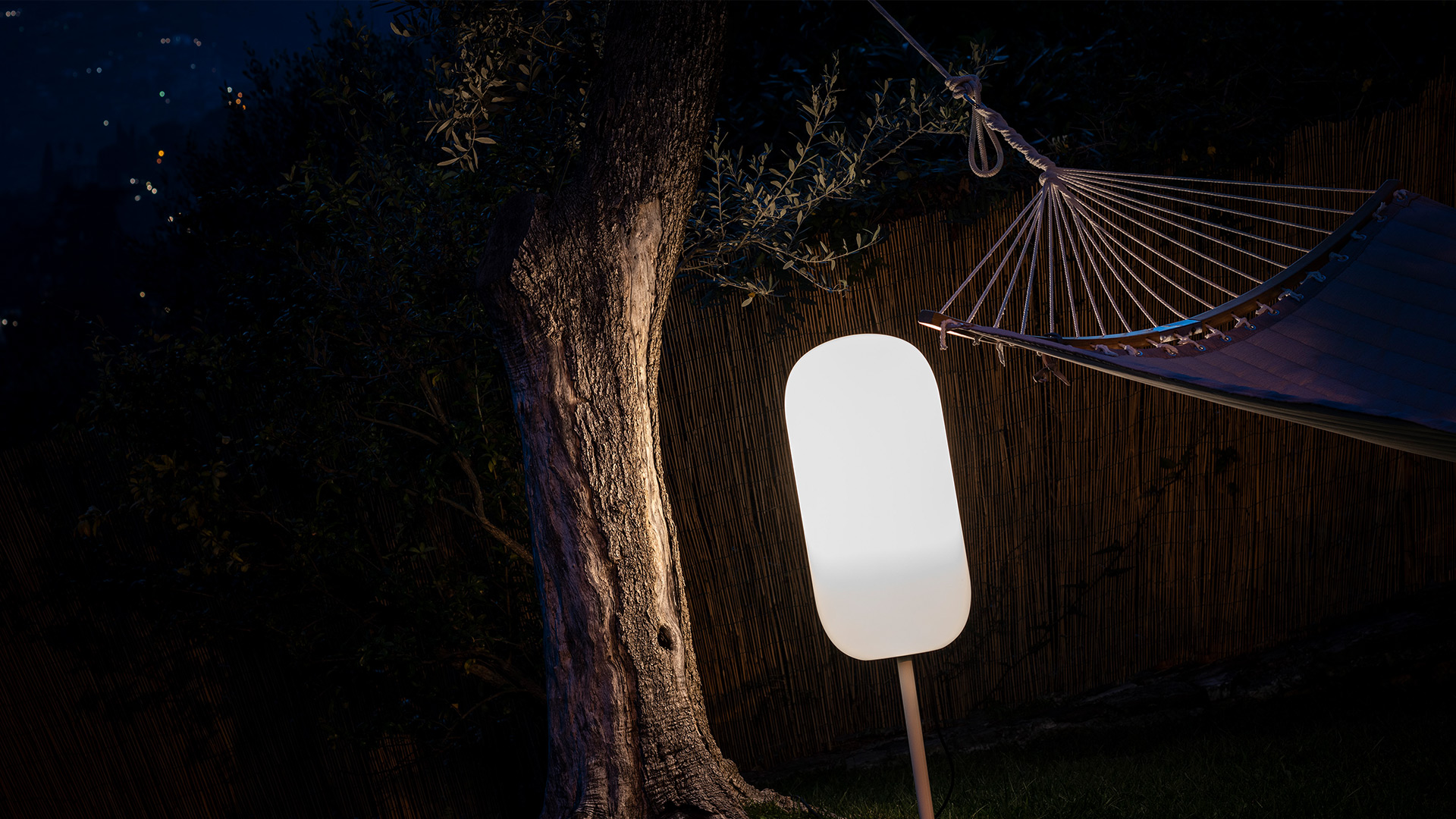 Lampade Artemide Gople Outdoor: una sospensione e una lampada da terra con due da tavolo, paralumi a capsula in vetro opalino bianco su sfondo azzurro