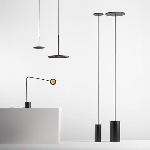 Collezione Artemide Helgoland: due lampade a sospensione nere, una lampada da tavolo con braccio articolato e due lampade da terra nere con basi cilindriche