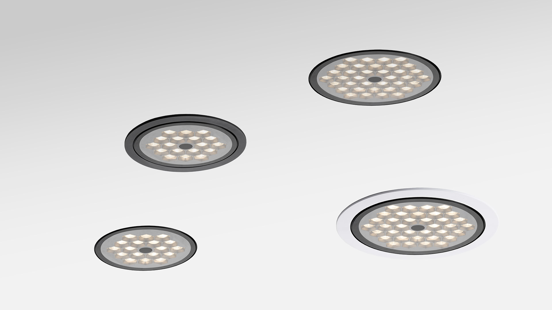 Quattro faretti da incasso a LED Artemide Helgoland IP44, due con bordo scuro e due con bordo bianco, che emettono luce diffusa calda