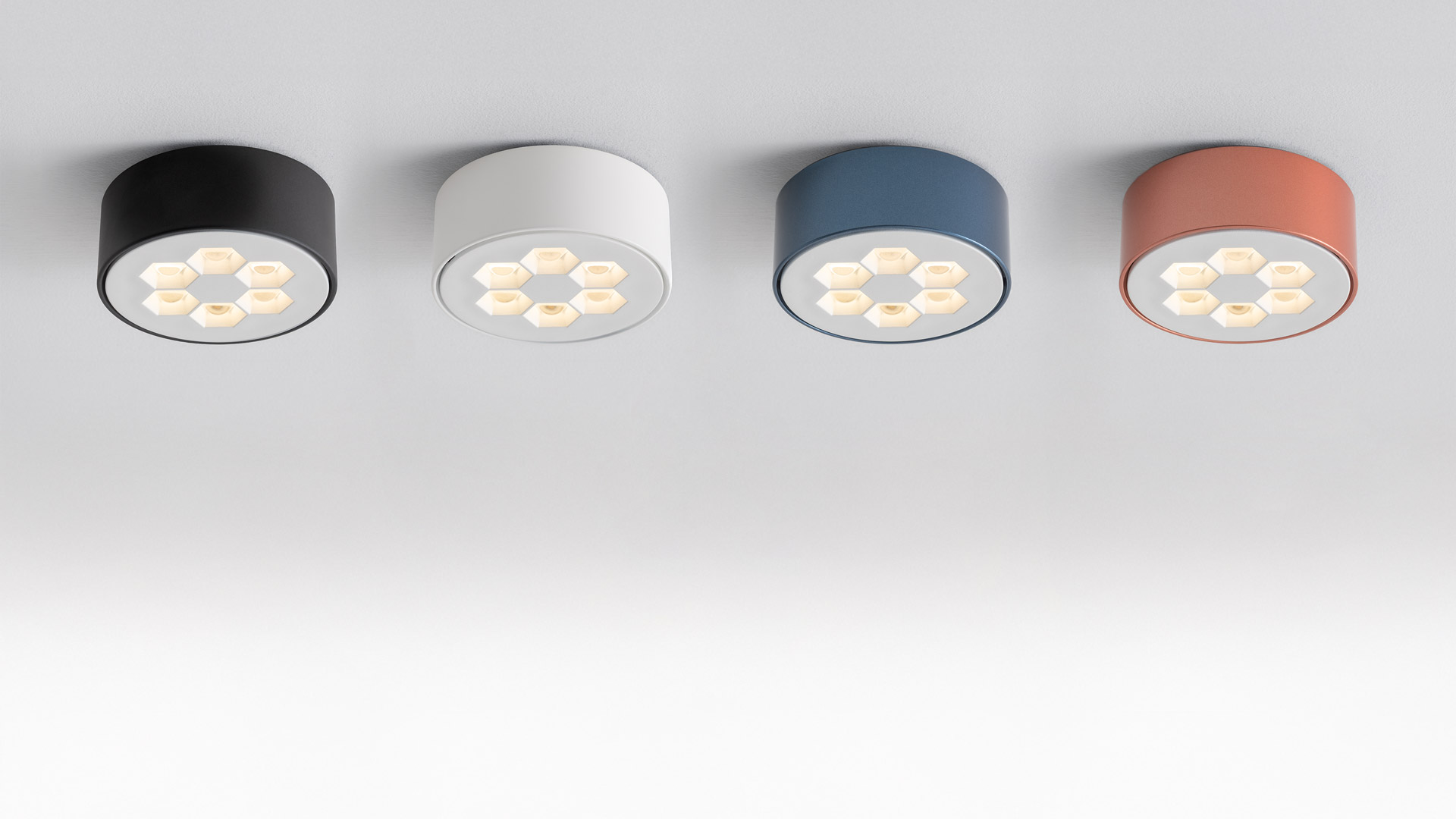 Corridoio ufficio moderno con luci da incasso a soffitto Artemide Helgoland, pareti in vetro, piante verdi rigogliose e ampie finestre.
