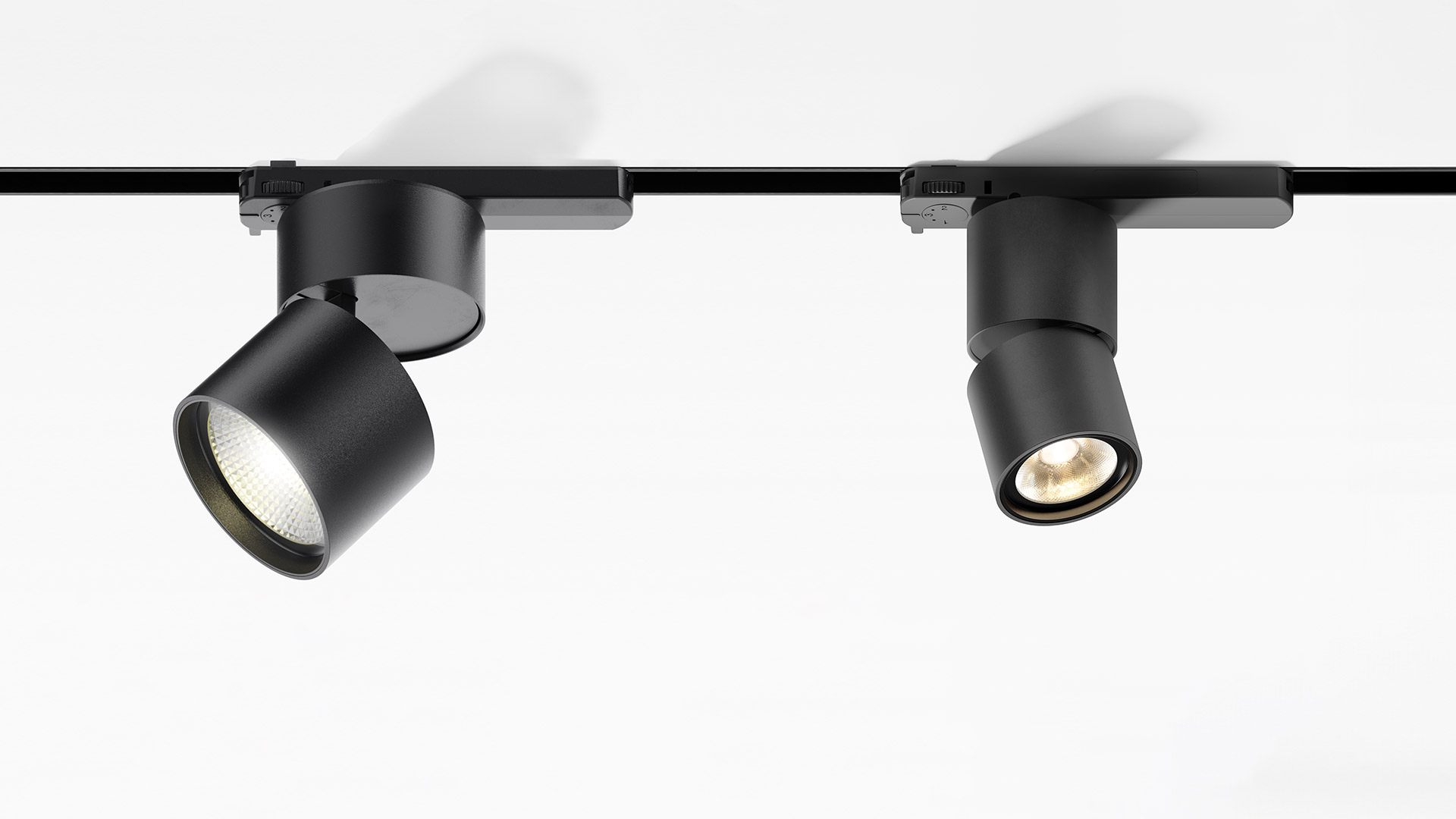 Tre faretti cilindrici bianchi Artemide Hoy Spot montati su binario trifase nero, orientati in direzioni diverse