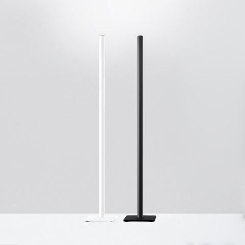 Lampade da terra Artemide Ilio: due colonne LED verticali ultrasottili su basi quadrate, una bianca e una nera, con luce verso l'alto
