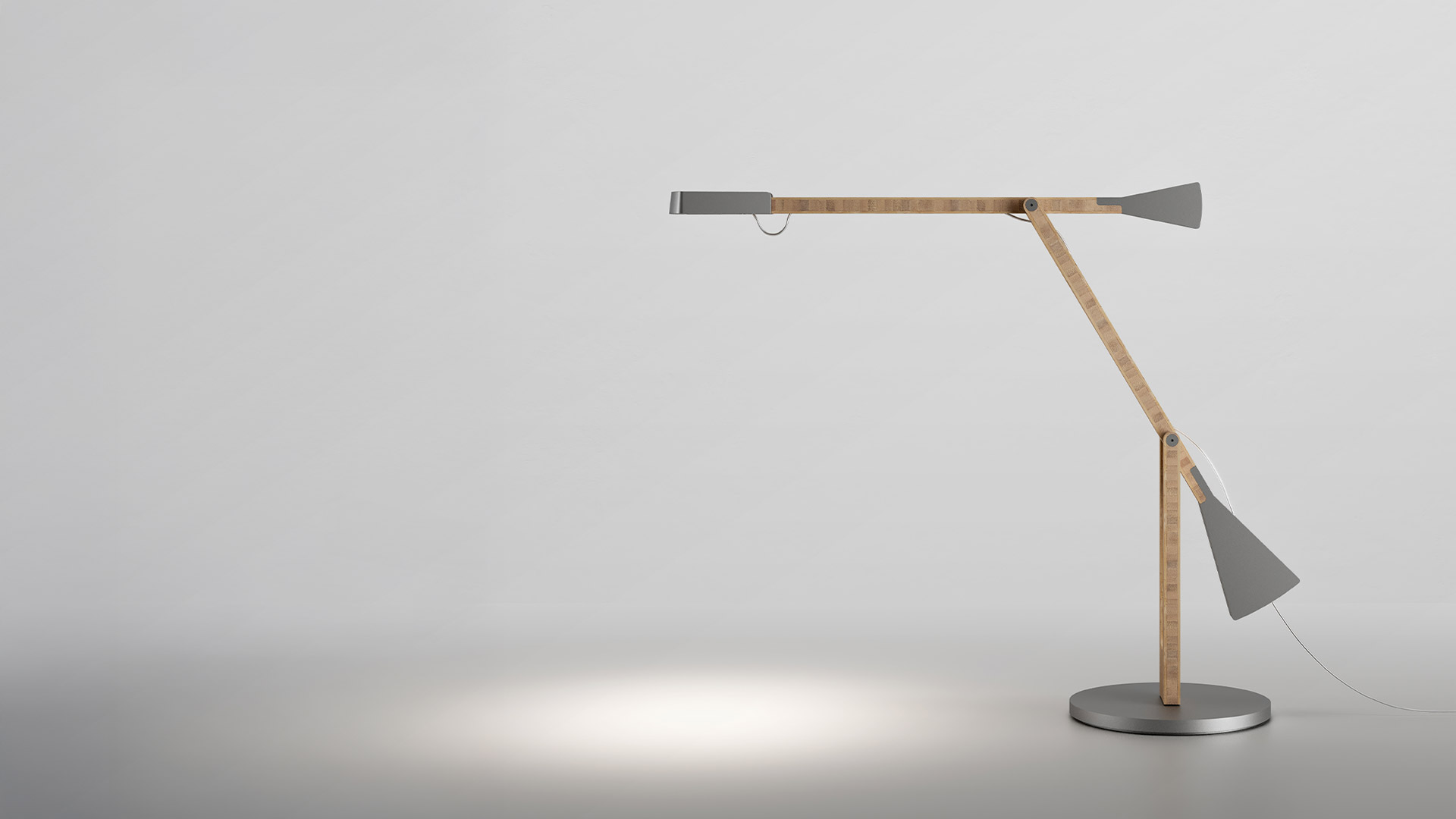 Artemide Internode desk lamp with articulated natural wood arm, metal joints, and circular base casting focused light downward