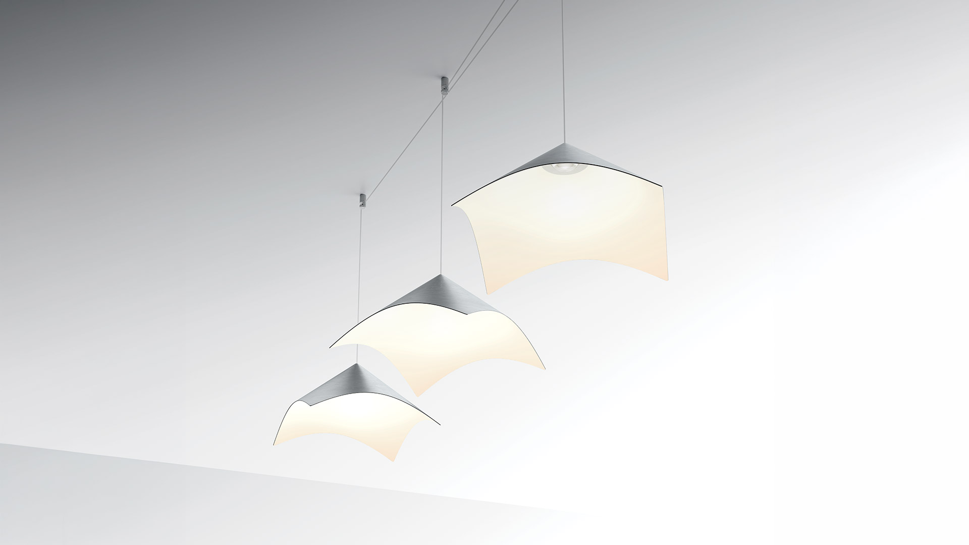 Artemide Iperbole pendant lamps with geometric zigzag metallic shades hanging over a desk scene with floating books and papers
