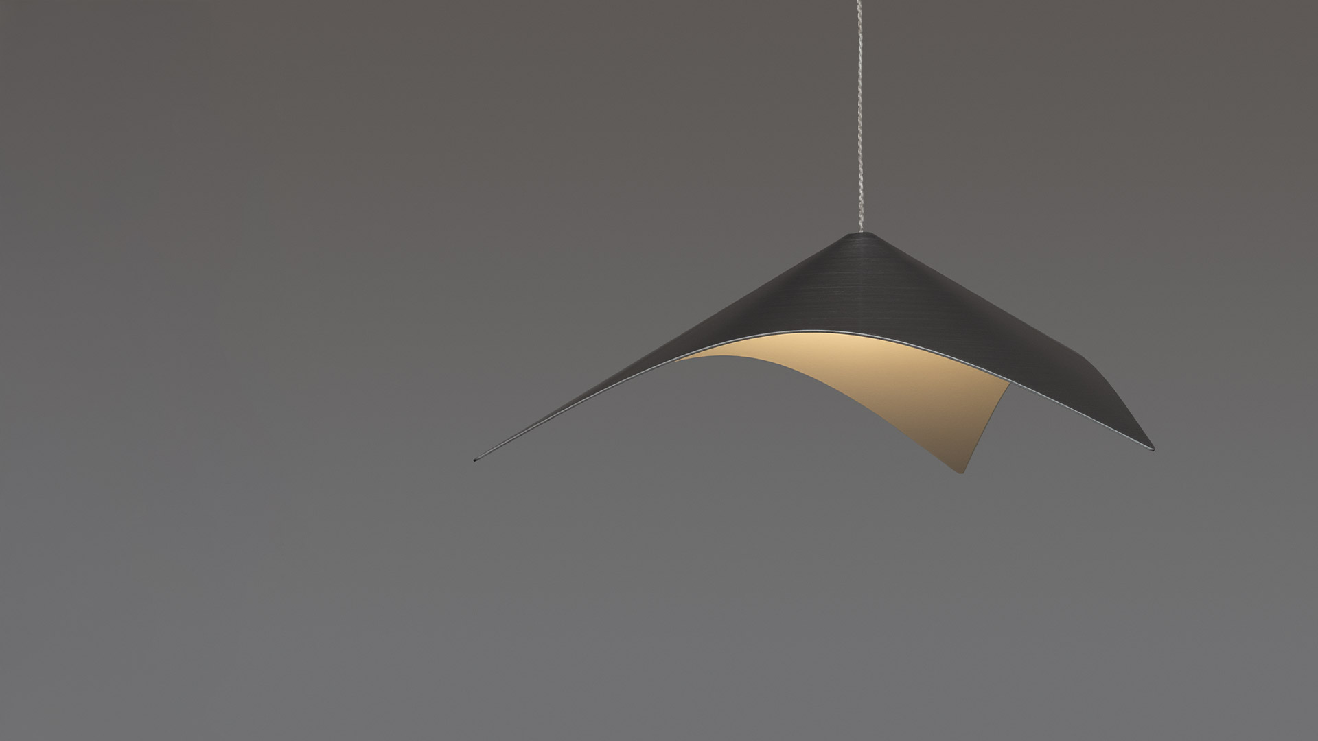Artemide Iperbole pendant lamp: asymmetric curved dark shade with warm golden inner surface, suspended by a thin wire