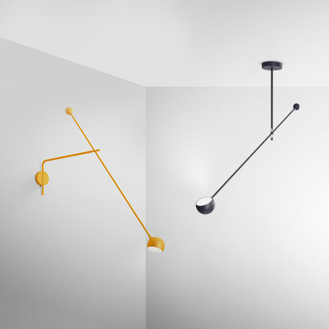 Due lampade Artemide Ixa: versione da parete gialla con bracci regolabili e paralume a cupola; versione da soffitto nera con asta controbilanciata