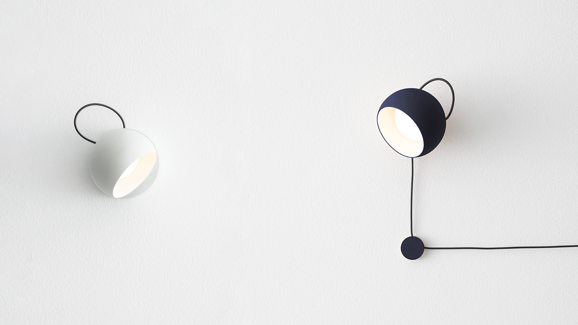 Sala da pranzo minimalista con tre lampade a sospensione Artemide Ixa in oro sopra un tavolo in legno con sedie nere