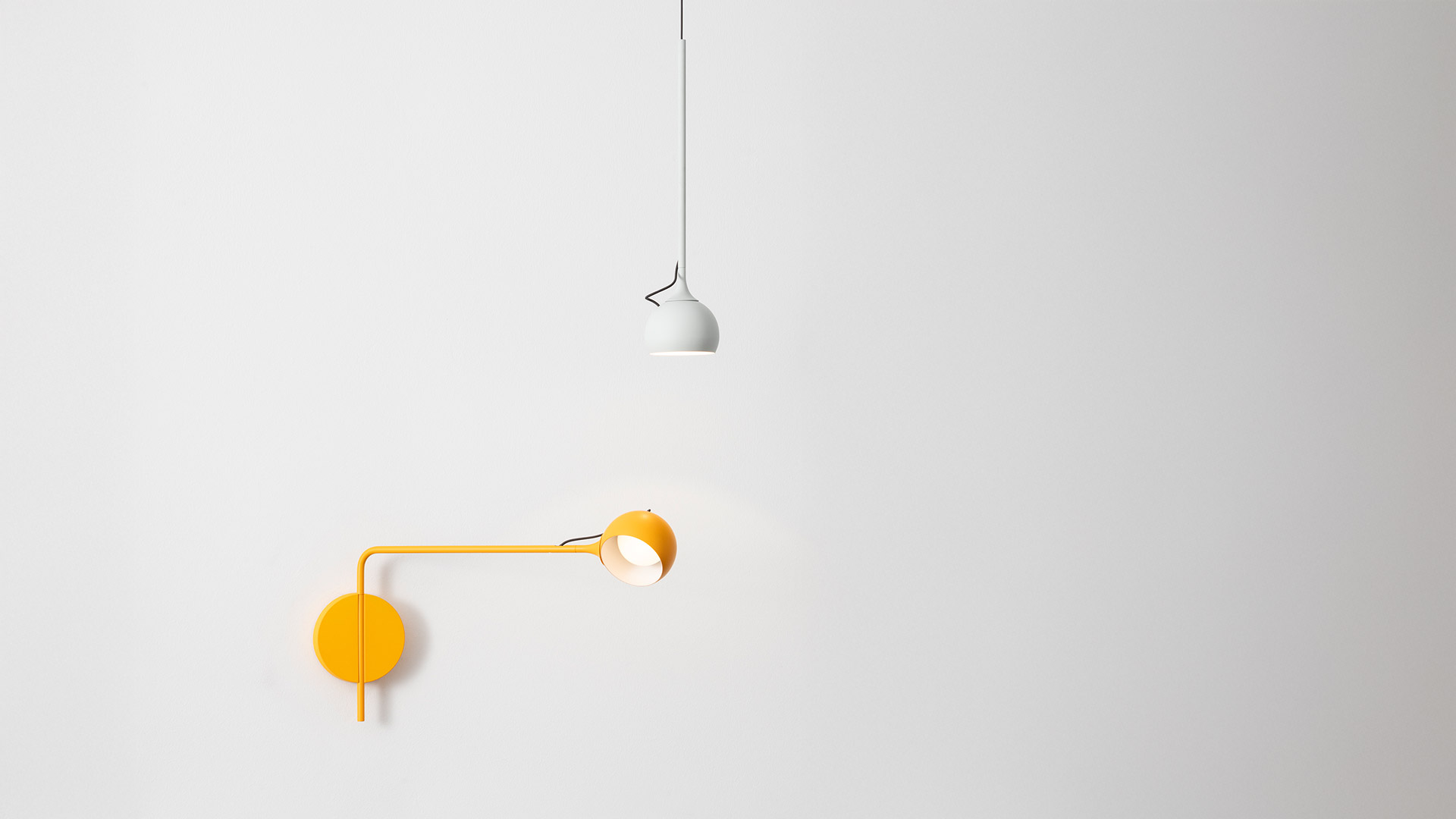 Lampada da parete Artemide Ixa blu navy montata sopra un comodino, che proietta luce calda e concentrata in una camera da letto accogliente