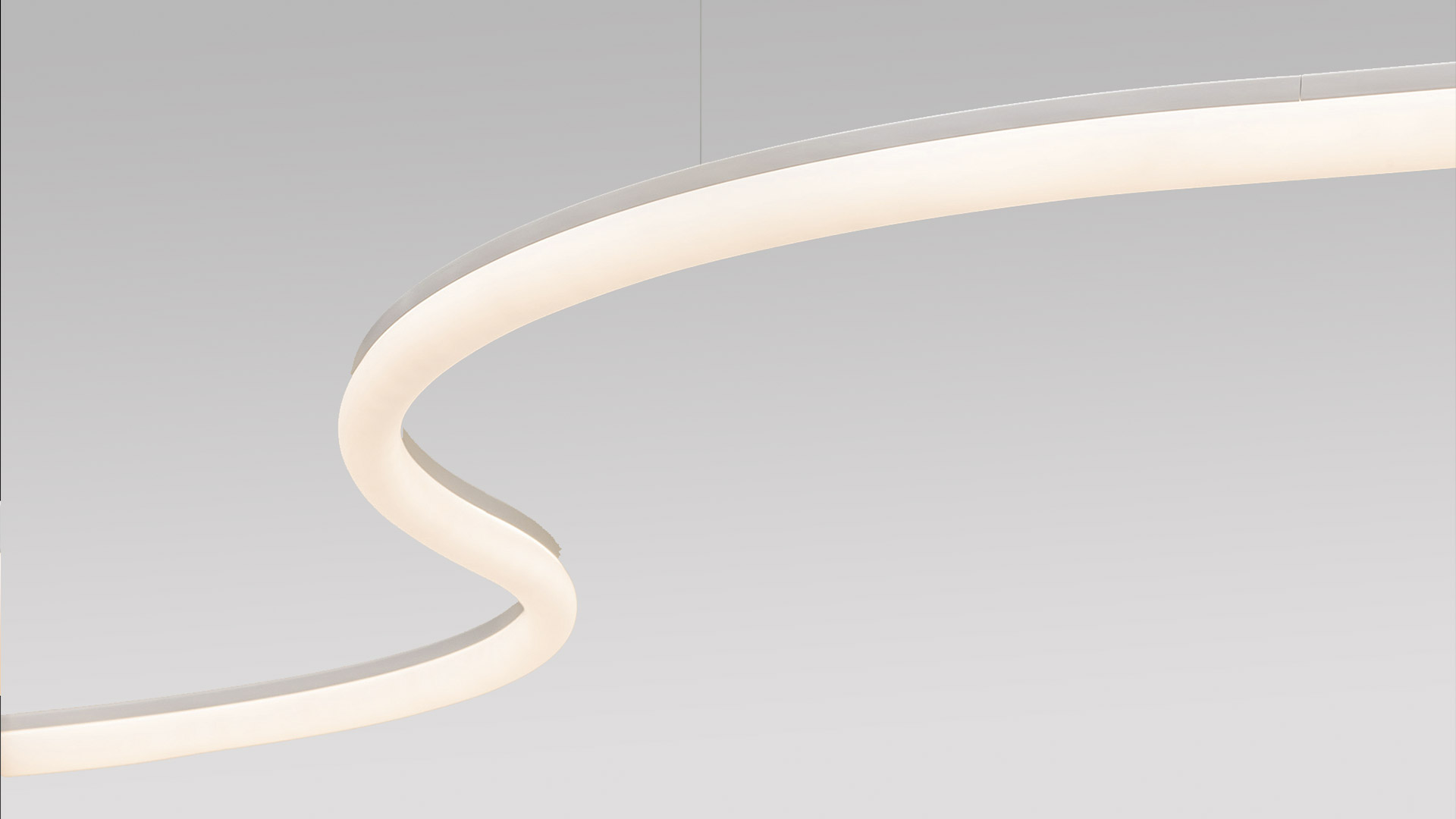 Due lampade cilindriche Artemide La Linea BIG con diffusori bianchi opali che emettono luce calda e soffusa, su superficie bianca