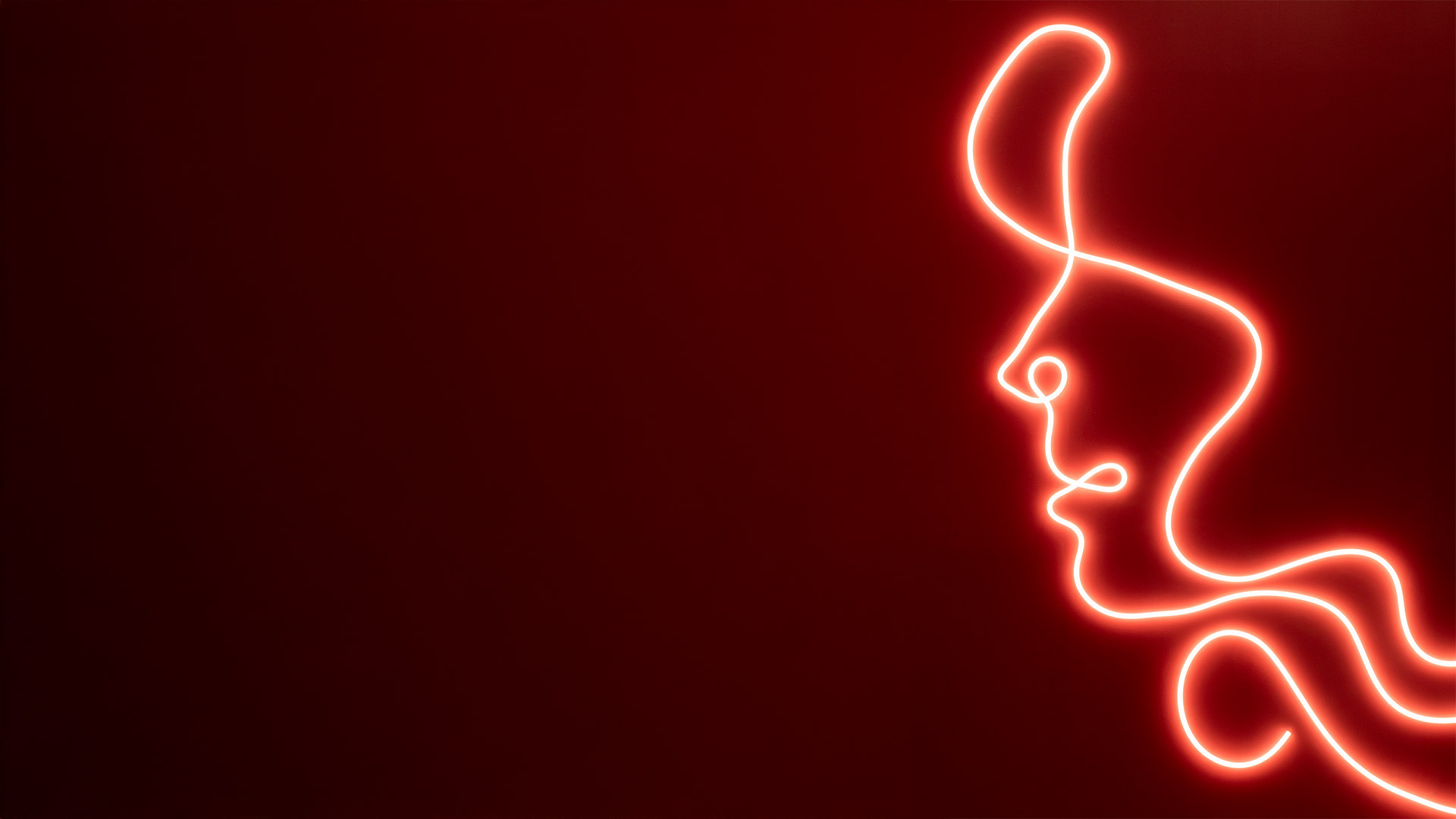 Artemide La Linea 25: tubo luminoso flessibile stile neon rosso che forma curve organiche astratte su sfondo rosso intenso