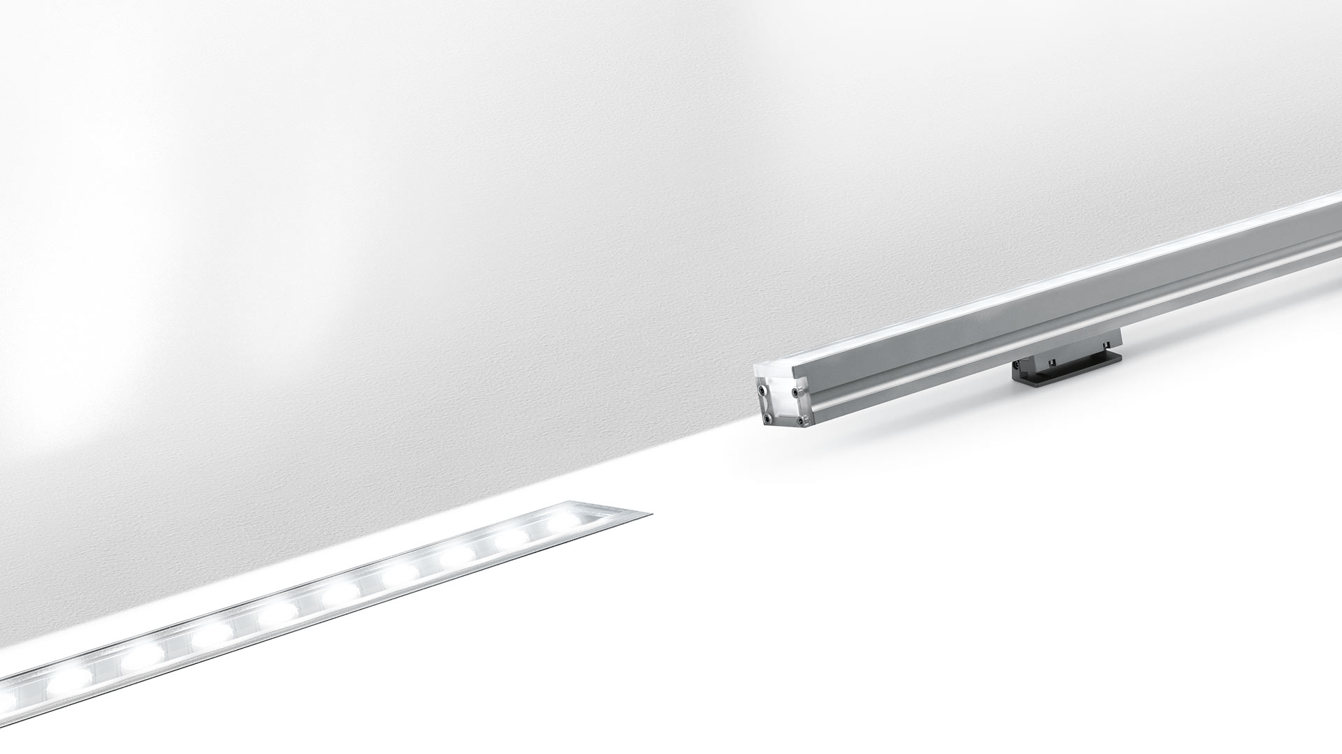 Artemide LineaLed Wallwasher: sottile apparecchio LED lineare da incasso con profilo in alluminio che emette luce uniforme lungo una superficie di parete bianca