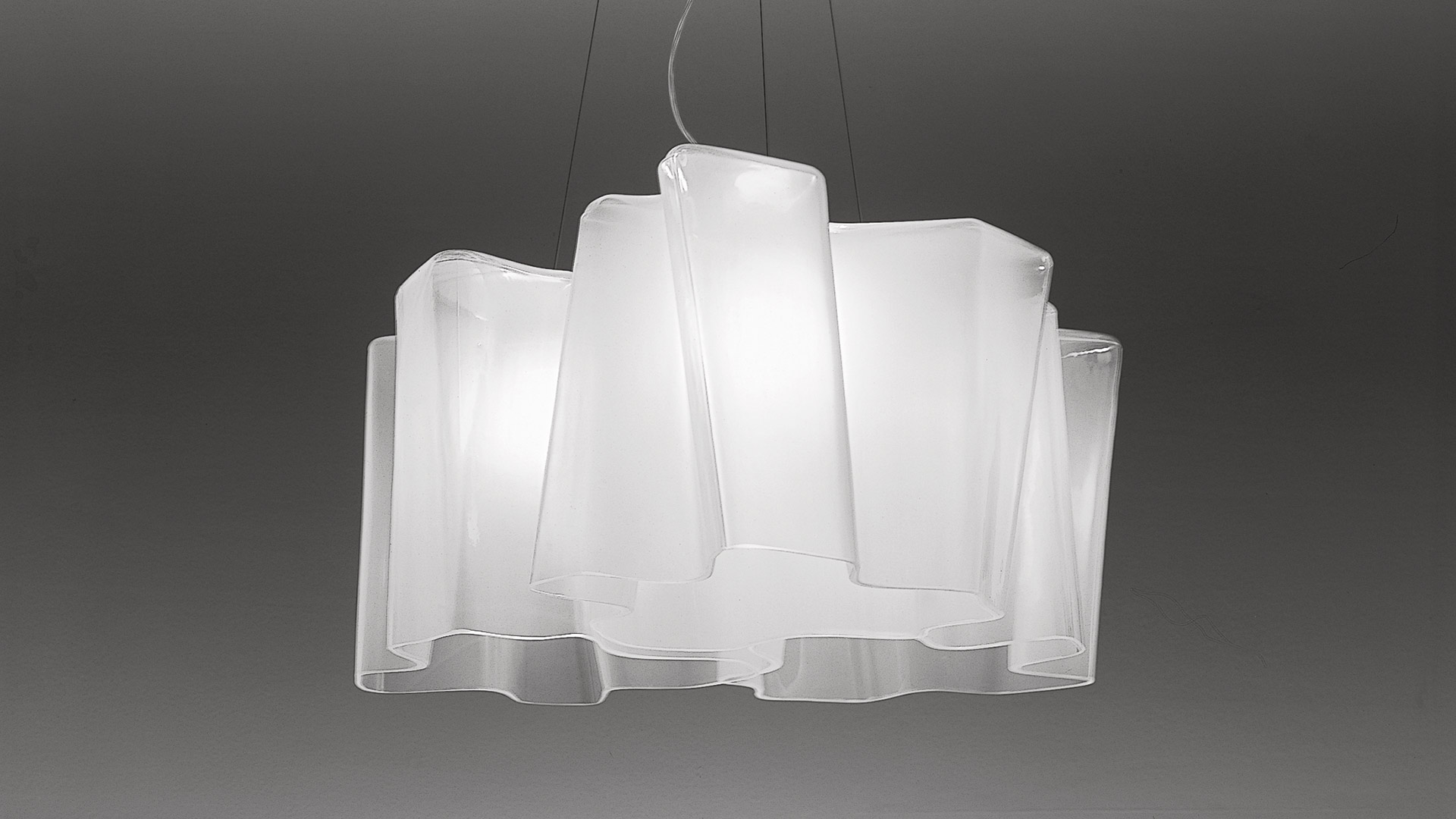 Artemide Logico sospensione 3x120°: tre diffusori in vetro opalino bianco sovrapposti disposti radialmente, che creano una lampada a sospensione simile a una nuvola