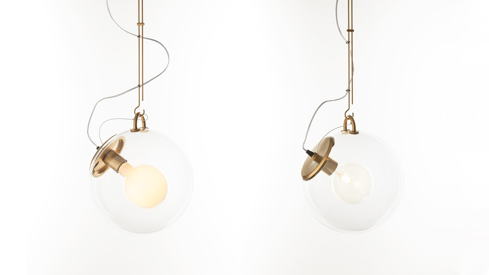Lampada a sospensione Artemide Miconos: sfera in vetro trasparente con anello cromato e cavo sinuoso, mostrata in vista completa e dettaglio
