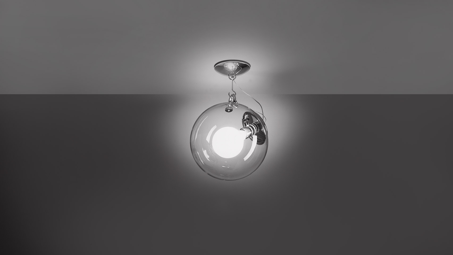 Lampada da soffitto Artemide Miconos: sfera in vetro trasparente con globo opalino interno, elementi cromati, montaggio a soffitto
