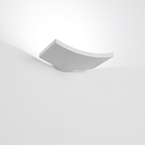 Artemide Microsurf white wall light with curved wing-shaped diffuser directing light upward along the wall