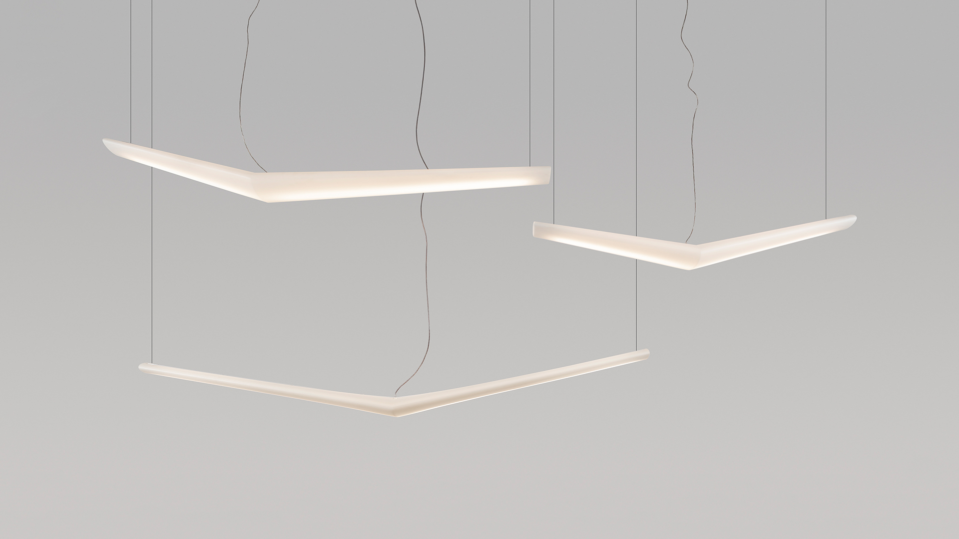 Tre lampade a sospensione Artemide Mouette con profili LED bianchi a forma di boomerang angolare appesi a sottili cavi