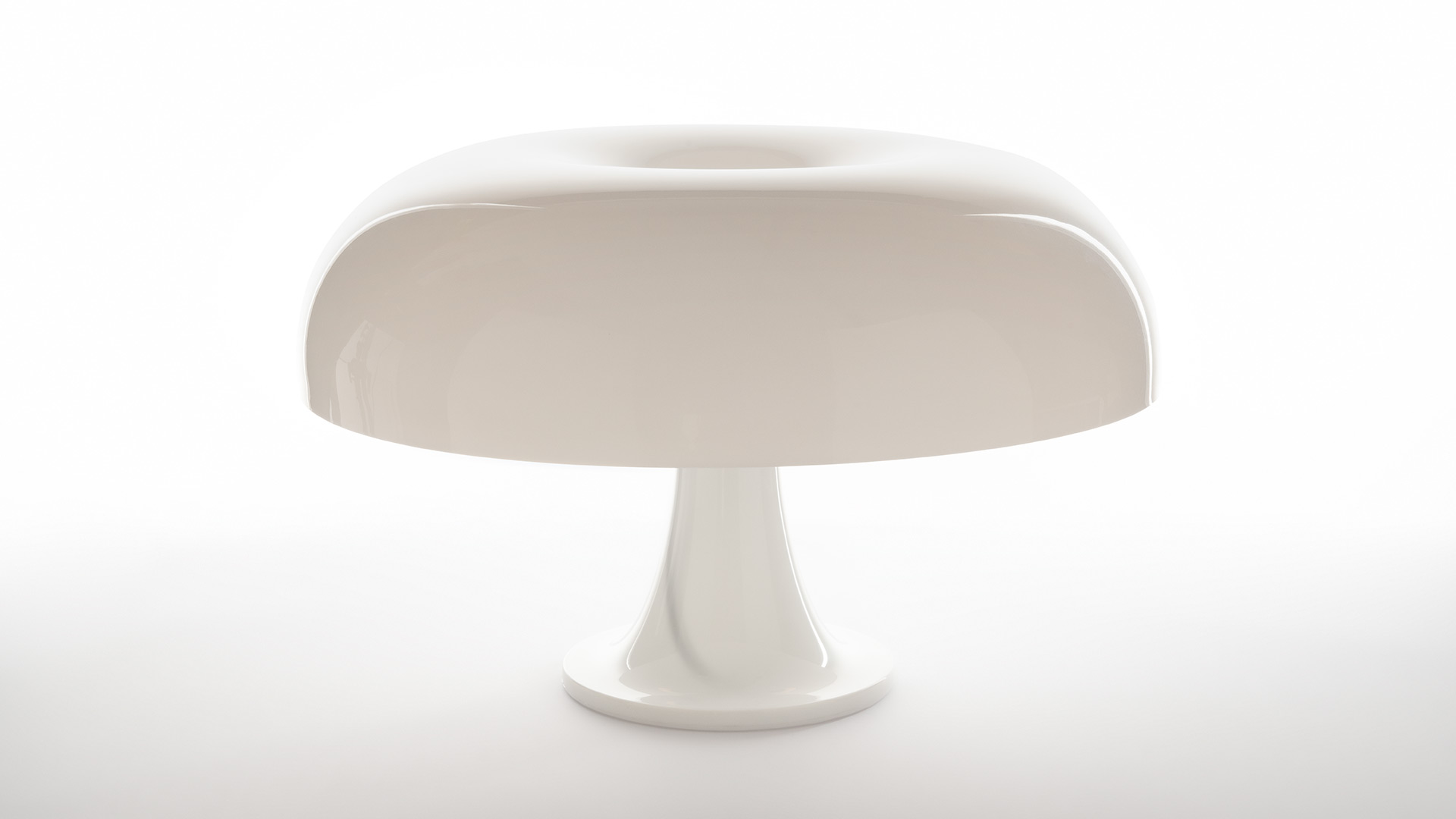 Lampada da tavolo Artemide Nesso in rosso bordeaux: iconica forma a fungo mostrata singolarmente e in un gruppo coordinato con accessori abbinati