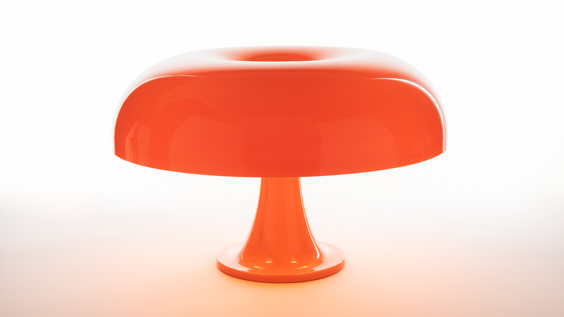 Due lampade da tavolo Artemide Nesso in rosso intenso, design a fungo, esposte su piedistalli scultorei rossi con tende di velluto