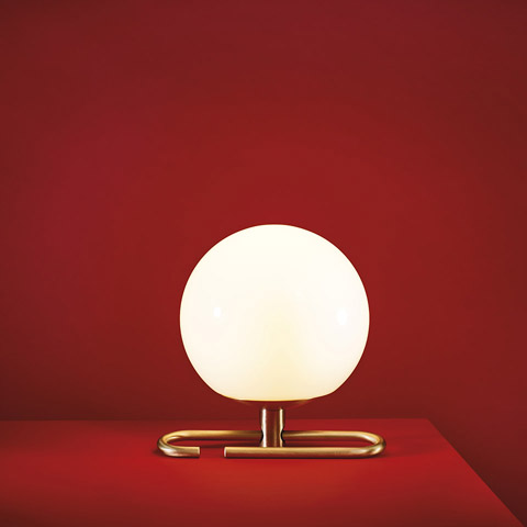 Lampada da tavolo Artemide NH1217: sfera in vetro opalino bianco luminosa su base rettangolare minimalista in ottone spazzolato, su sfondo rosso