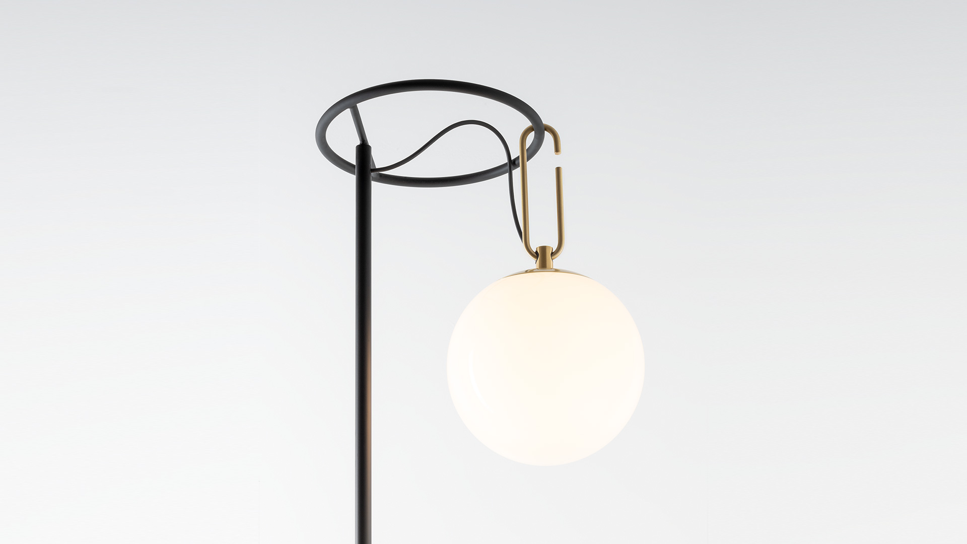 Lampada da terra Artemide nh Terra: anello circolare nero su palo verticale con globo in vetro satinato appeso tramite gancio in ottone