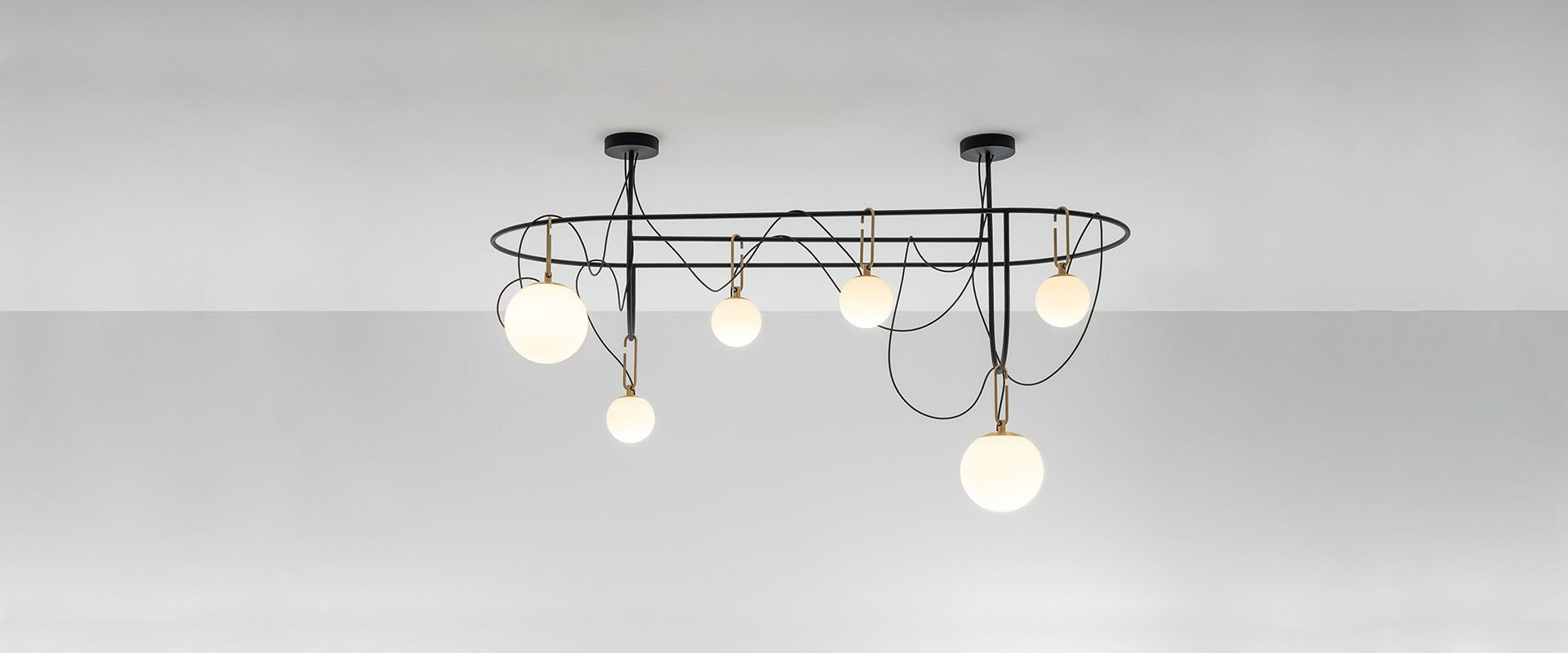 Artemide NH suspension lamp: black horizontal bar with three opal glass spheres hanging at different heights on curved black wires
