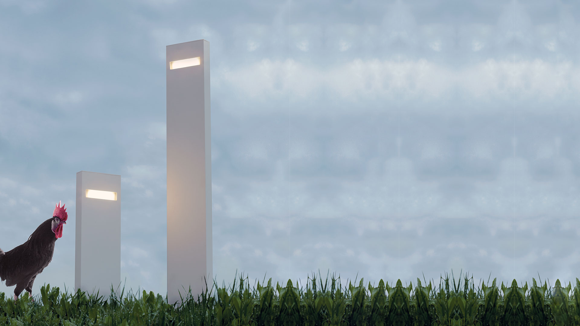 Ingresso di edificio moderno al crepuscolo con paletti luminosi Artemide Nuda lungo un vialetto di ghiaia su prato curato