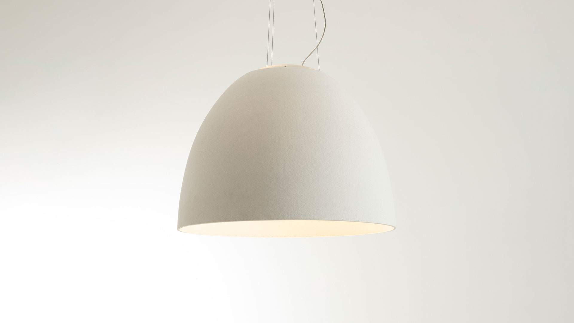 Close-up of Artemide Nur Acoustic pendant lamp shade: white textured acoustic fabric exterior with warm beige interior lining