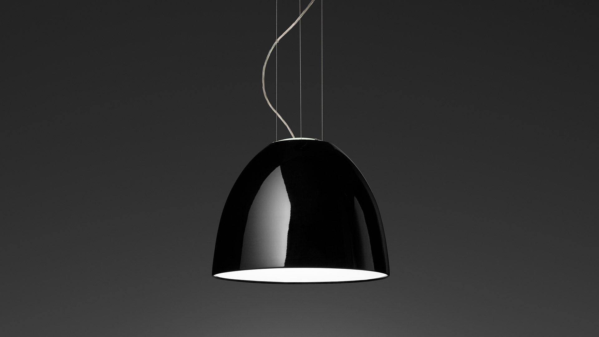 Lampada a sospensione Artemide Nur Mini Gloss con paralume a cupola nero lucido e interno bianco, sospesa da sottili cavi