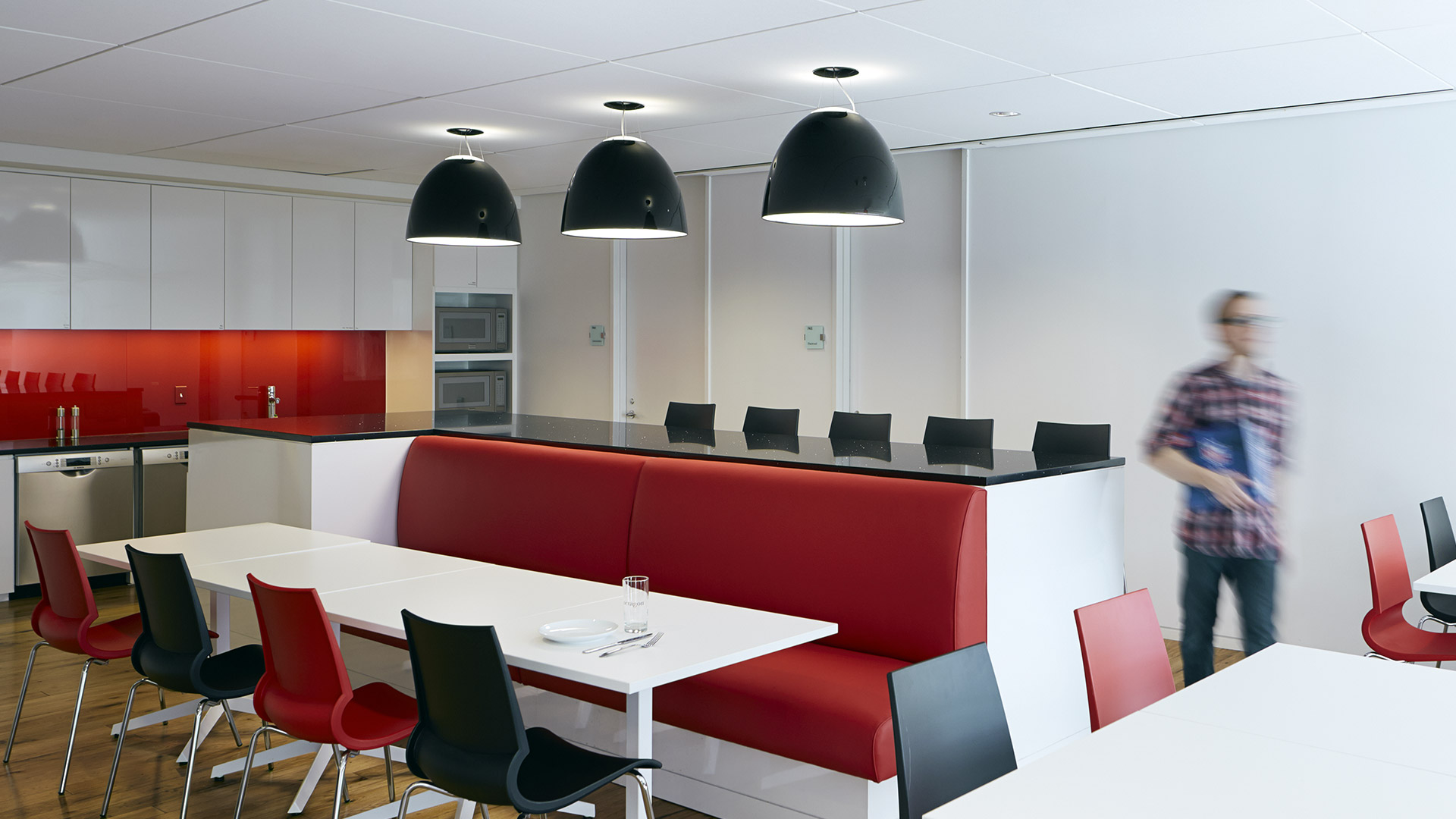 Lampada a sospensione Artemide Nur Gloss con paralume a cupola bianco lucido, sospesa da un cavo su sfondo scuro