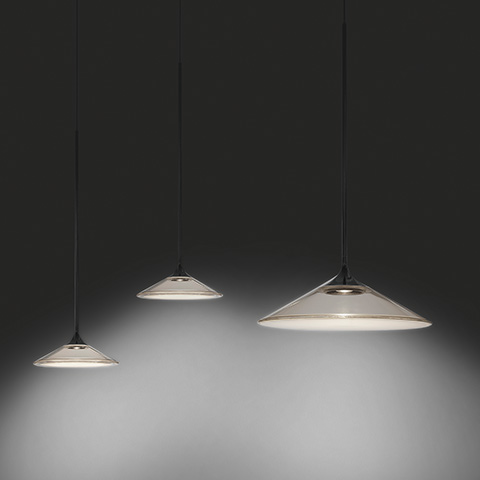 Three Artemide Orsa pendant lamps in graduated sizes, conical transparent glass shades with white diffuser, suspended on black cords