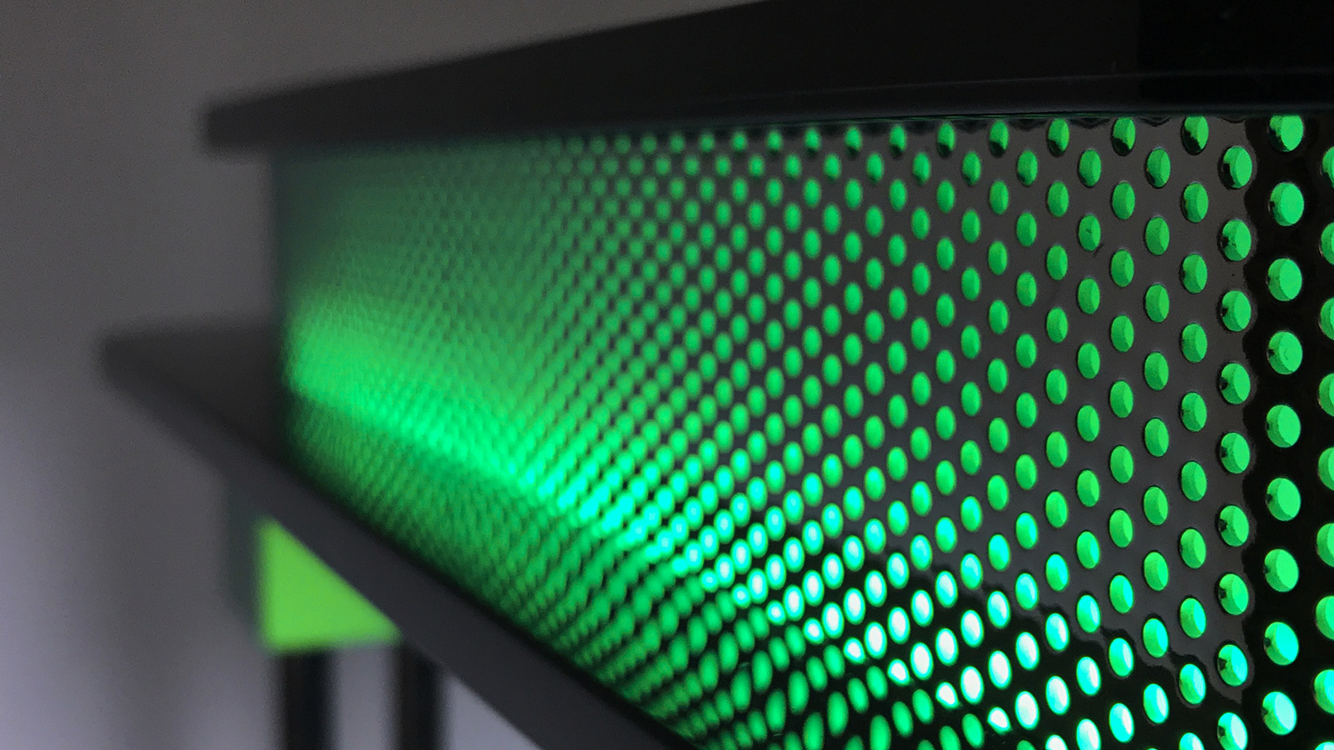 Dettaglio lampada Artemide Pausania: diffusore cilindrico forato verde con piastre circolari nere superiore e inferiore su stelo cromato