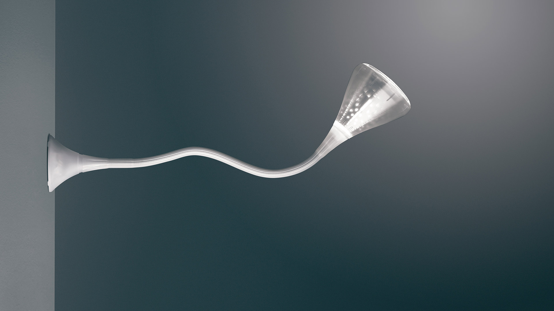 Lampada da parete Artemide Pipe: braccio bianco sinuoso si estende dalla parete, terminando in un diffusore LED a tromba svasata che emette luce calda